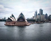 Blick vom Wasser aus auf die Oper von Sydney und die Skyline der Metropole in Australien.