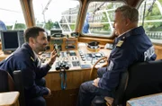 An Bord der Silbermöwe zeigt Fahri Celik (Hassan Akkouch, l.) Axel Sommer (Oliver Breite, r.) ein Geschenk, das er seiner Verlobten machen möchte.