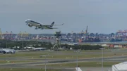 Der Flughafen Sydney liegt am Rande des Pazifischen Ozeans, mit einer Ölraffinerie auf der einen Seite und der Metropole Sydney auf der anderen.