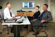 Der Abariskonzern-Chef Alexander Weber (Heio von Stetten, rechts) fordert von Dr. Roland Heilmann (Thomas Rühmann, links) kürzere Liegezeiten. Die gründliche Dokumentation von Clemens Manthey (Max König) hat Optimierungspotential ergeben. Roland weigert sich und verweist die Herren auf seine medizinische und fachliche Kompetenz.