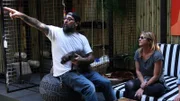 Host Antonio Ballatore holds his dog Edie while pointing to something with build crew member Christina Ray.