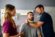 Elisabeth Hertz (Henrike Hahn, l.) unterstützt Dr. Julius Walden (Constantin Lücke, r.) bei der Behandlung von Dr. Tarik Şahin (Nicolas Fethi Türksever, M.).