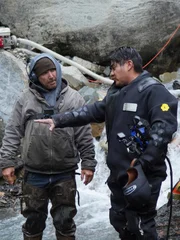 L-R: Carlos Minor conversing with Dustin Hurt next to the water.