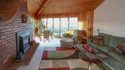 The living room in the Island View House features a large and unique brick fireplace, as seen on HGTV's Beach Hunters.