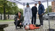 Nach einer Probe mit seinem Streichtrio liegt der Bratschist Tobias Hammer (Komparse, M.) tot auf dem Vorplatz der Nikolaikirche. Der Berufsmusiker wurde erschlagen, unmittelbar nachdem er die Probe verlassen hatte. Wer hat ihn umgebracht? Kriminaltechnikerin Roswitha Prinzler (Silke Matthias, 2.v.l.) und Austauschpolizist Eddi Jansons (Gustavs Gailus, 2.v.r.) geben den Kriminalkommissaren Karoline Joost (Nike Fuhrmann, l.) und Lars Pöhlmann (Dominic Boeer, r.) erste Informationen zum Fall.