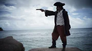In a recreation, La Buse points his gun in the pirate paradise of the Indian Ocean.