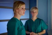 Dr. Roland Heilmann hat die schwere und hochriskante OP zwar überstanden, aber er hatte etwa 45 Minuten Kreislaufstillstand. Dr. Lea Peters (Anja Nejarri, links) soll die Ärzte als Neurochirurgin unterstützen. Sie und Dr. Kathrin Globisch (Andrea Kathrin Loewig) haben Rolands Körpertemperatur auf 33 °C gesenkt, um eventuelle Schäden im Gehirn möglichst gering zu halten. Doch niemand weiß, wie viel Schaden Rolands Hirn schon genommen hat. Für Lea ist die Situation fast unerträglich - der Messerangriff galt eigentlich ihr.