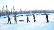Lewis Family and their dog walking through the snow.