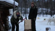 Tyler and Ashley Selden chopping wood outside their cabin.