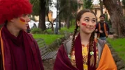 Lucy (Kensington Tallman, r.) und Nico (Christian Monaldi, l.) tragen Schals und Perücken in den Farben ihrer Fußballmannschaft - orange und rot.
