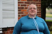 Mary standing near a house.