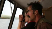 Ray and his daughter looking out of the boat windows with a binocular.