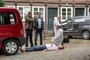 Die Kommissare Finn (Sven Martinek, l.) und Lars (Ingo Naujoks, 2.v.l.) kommen an den Tatort, an dem der Musiker Kai Scherer (Zio Tristan Mundry, liegend) am helllichten Tag erschossen wurde. Rechtsmediziner Dr. Henning Strahl (Christoph Tomanek, r.) hat mit seinem Team bereits die Projektile sichergestellt.