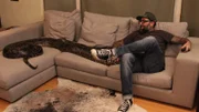 Host Antonio Ballatore sits on the couch with the large python.