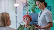 Jenny Chan (Yvonne Yung Hee Bormann, re.) platzt mit dringenden Neuigkeiten in Kathis (Jördis Triebel, li.) Termin mit Frau Baumüller (Eva Weißenborn, Mitte).