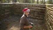 Heimo working on their wood cabin.