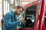 Gregor (Jonas Minthe) untersucht die zerstörte Fensterscheibe am Auto des Mordopfers.