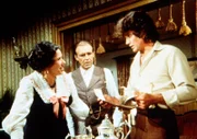 Charles Ingalls (Michael Landon, r.) teilt der entsetzten Mrs. Oleson (Katherine MacGregor, l.) mit, dass ihr günstig erworbenes Silberservice Diebesgut ist. Mr. Oleson (Richard Bull, M.) hört gespannt zu.