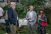 Bill Bradwell (James Cosmo, l.) ärgert sich darüber, dass sich sein Sohn Mark (Steven Robertson, M.) und dessen Frau Stella (Sunetra Sarker, r.) während einer Gartenparty über Geschäftliches unterhalten möchten.