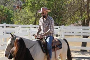 Host Antonio Ballatore rides a horse.