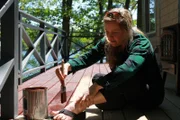 Designer Ashley staining the deck for the Houghton family build, at Damariscotta Lake, Maine, as seen on DIY Network's Maine Cabin Masters.