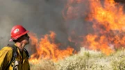 Ein Feuerwehrmann bereitet sich auf den Einsatz beim Apple Fire in den San Bernardino Mountains vor.