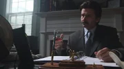 Larry McNabney works with a glass of wine in his hand.