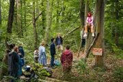 Elly (Nelly Borodina, oben) gibt in der Verhandlung mit Herrn Chung (Ill- Young Kim, 6.von links) und Frau Holopainen (Meri Koivisto, 5. von links) nicht nach.