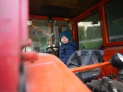 Der zweijährige Benjamin Penner übt sich schon früh im Traktorfahren.