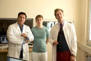 In der Praxis drohen Piwi (Meo Wulf, M.) Schwierigkeiten, nachdem der Manager Stefan Dangelmann während seiner Physiotherapie über Rippenschmerzen klagt. Falls es Christian (Francis-Fulton Smith, l.) und Dr.Timotheus von Hatzfeld (Tom Radisch, r.) nicht gelingt, Piwi mit einer ärztlichen Diagnose zu entlasten, könnte seinem Sohn eine saftige Klage drohen.
