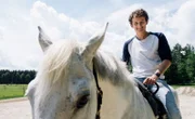 Julian checkt mit Pferd "Burli", wie ein Pferd geröngt wird.
