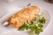 Das „Raan Jae Fai“ in Bangkok serviert eine einzigartige, gerollte Version von „Khai Jiao“, dem beliebten, frittierten Omelett nach thailändischer Art, das oft mit Schweinefleisch oder Meeresfrüchten gefüllt ist.