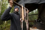Chevie Roach hängt frisch gefangenen Fisch auf ein Trockengestell. (National Geographic/Brad Carper)