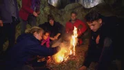 Wildniscoach Tobi bringt dem Team bei, nach Steinzeitart Feuer zu machen.