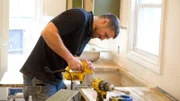 Before shot of Evan Thomas working on the countertops at the Rainforest house, as seen on Bargain Block, Season 4.