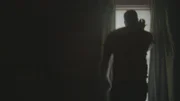 Ein Mensch steht neben dem Fenster