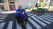 Janine riding her scooter at her apartment.