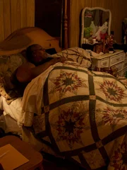 Lisa is laying in bed at home.