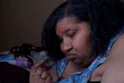 Renee is on her bed reading a book.