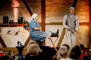 Bevor sich Bäuerin Lena (Hillu's Herzdropfa) bei dem Verkäufer (Franz Auber / Hillu's Herzdropfa) neue Schuhe kauft, bleibt sie lieber bei ihren treuen Gummistiefeln.