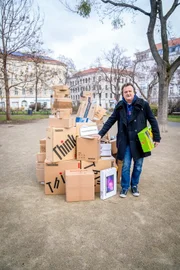 Hanno Settele neben einem Stapel aus nicht ausgelieferten Paketen. Für einen Tag sind alle ausländischen Arbeitskräfte verschwunden und somit auch die fleißigen Lieferant:innen, die unsere Pakete normalerweise zustellen. „Selbstbedienung“ ist angesagt.