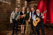 Die Musikgruppe Brettl-Spitzen Musi. Von links: Bernhard Gruber, Katharina Baur, Florian Gröninger und Berni Filser mit Moderator Jürgen Kirner.