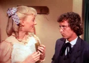 Die schwangere Nellie (Alison Arngrim, l.) schlingt Essiggurken und Sahneeis in sich hinein. Ihr Mann Percival (Steve Tracy, r.) fürchtet sehr, dass seine Frau so dick wie ihre Mutter wird.