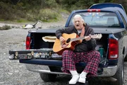 Ein Mann spielt die Gitarre und singt