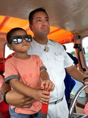 Kapitän Robert Fronenbroek fährt vor Tonga Tenderboot mit einem Kind, das er vor einiger Zeit aus Seenot gerettet hat.