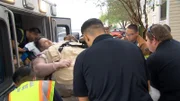James is unloaded from the ambulance into his new apartment.