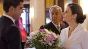 Dona Blanca und Don Emilio (Mitte, José Sacristán) beauftragen den jungen Verkäufer Max (l., Maxi Iglesias), Cristina (r., Aitana Sánchez-Gijón) anlässlich der Rückkehr von ihrer Hochzeitsreise einen Blumenstrauß zu überreichen.