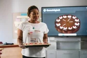 Frau Miesbach (Liz Baffoe) möchte das neue Rechtsmodul anschaulich gestalten und hat sogar einen Kuchen in den Unterricht mitgebracht.