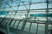 Internationaler Flughafen Dubai - Blick durch die Glasfenster des Terminals auf das Boarding eines Flugzeugs.