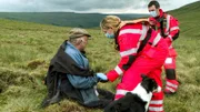 James Stubley (l) und Rachel Smith (m)  beugen sich über einen Patienten im Moor